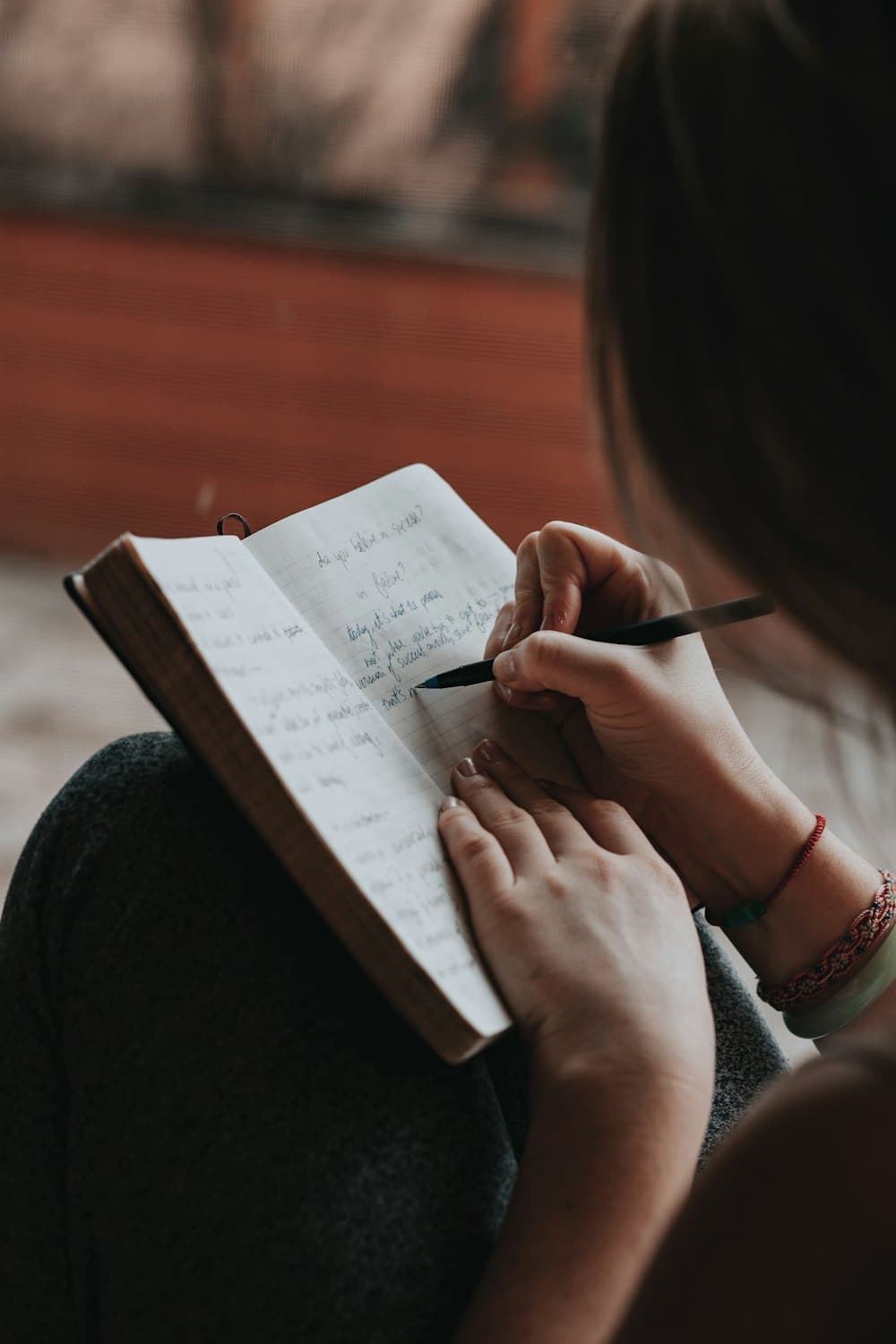 Mãos escrevendo em um caderno aberto
